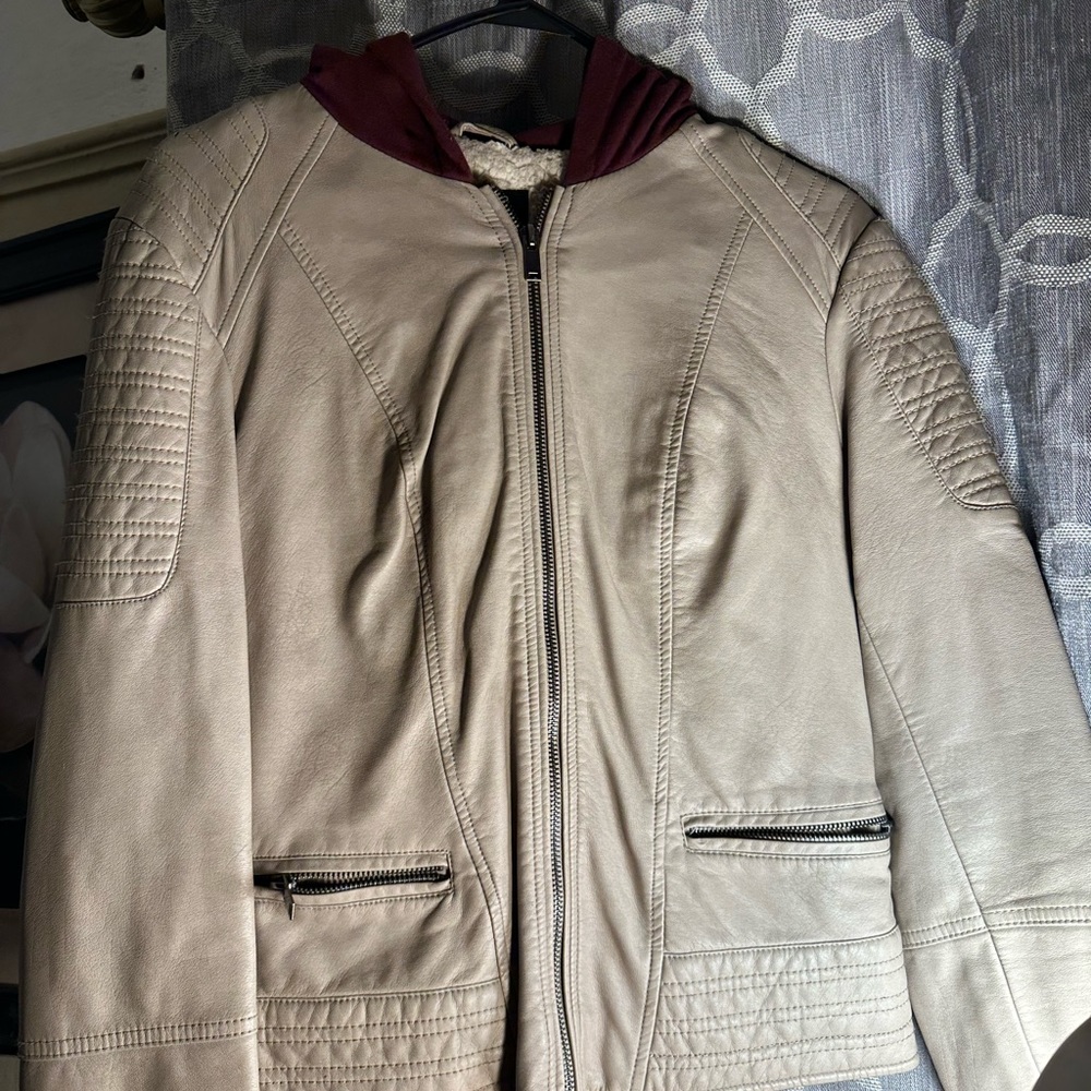 Im selling a cream leather jacket.It has a red hoodie in the back.